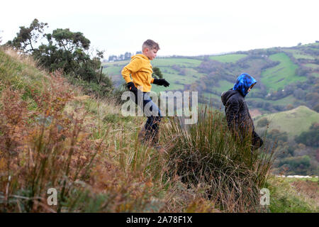 Enfants garçons courant le long de la randonnée dans la campagne à mi-saison à l'automne en Carmarthenshire Wales UK KATHY DEWITT Banque D'Images