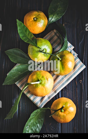 Mandarine avec des feuilles sur un pays à l'ancienne table. Focus sélectif. La verticale. Banque D'Images