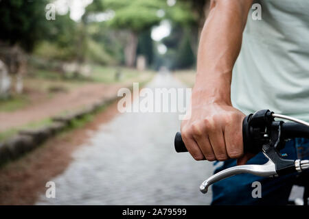 Libre d'un young caucasian man riding a bike par la route Via Appia Antica à Rome, Italie Banque D'Images