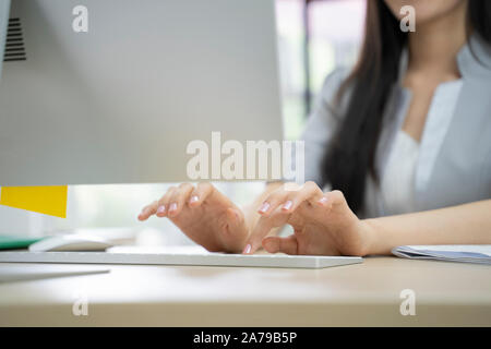 Tiré d'une belle femme d'affaires asiatiques travaillant sur ordinateur dans sa station de travail. Banque D'Images
