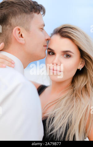 Jeune homme en chemise blanche s'embrasser blond woman wearing robe noire en hiver steppe. Banque D'Images