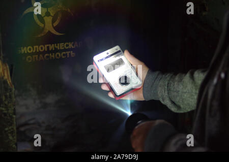 Un homme avec un biorisque compteur et une lampe avant qu'un avertissement sur le danger. Biologie du virus et symbole d'avertissement sur mur détruit. Illustra de rendu 3D Banque D'Images