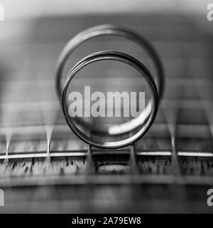 Deux anneaux de mariage sur les cordes de guitare. Profondeur de champ Banque D'Images