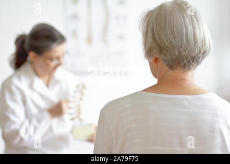 Le vieillissement et la douleur dorsale concept : senior patient consulter son médecin à cause de la hernie discale. Banque D'Images