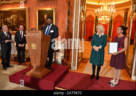 La duchesse de Cornouailles poète écoute Ben Okri s'exprimant lors d'une réception pour les gagnants du concours de rédaction du Commonwealth de la reine au palais de Buckingham à Londres. Banque D'Images
