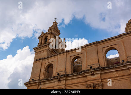 La Cathédrale St Paul clocher tourné à partir de l'angle faible contre blue cloudy sky, à Mdina, Malte. Banque D'Images