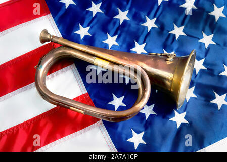 Old brass bugle sur le drapeau américain. Banque D'Images