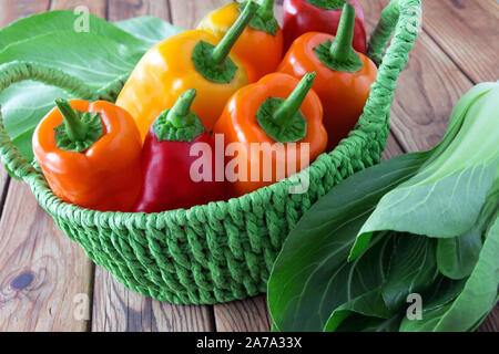 Paprika et Pak choi dans un panier sur un fond de bois Banque D'Images