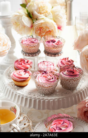 Une belle composition de rose rose et cup cakes sur une table de luxe Banque D'Images