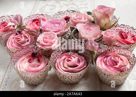 Une belle composition de rose rose et cup cakes sur une table de luxe Banque D'Images