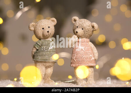 Figurines décoratives d'un thème de Noël. Univers miniatures d'adorables nounours d'un garçon et une fille dans les chandails avec des daims. Décor de fête, chaud bokeh lights Banque D'Images