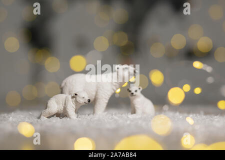 Figurines décoratives d'un thème de Noël. Statuettes d'une famille d'ours polaires. Décoration d'arbre de Noël. Décor de fête, chaud bokeh lights Banque D'Images