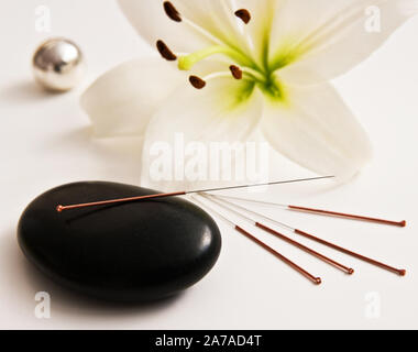 Lily avec les aiguilles d'acupuncture et de la pierre Banque D'Images