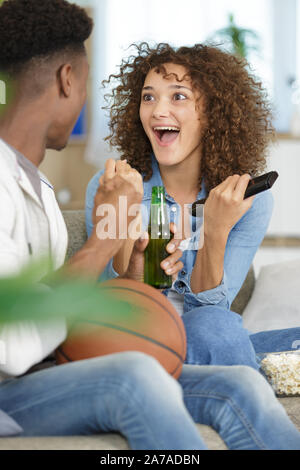 Couple heureux sur le canapé en regardant la télé Banque D'Images