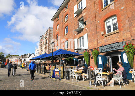 Sur le front de bar et pizzeria dans les voûtes en briques du 19e siècle les entrepôts, à l'automne, le soleil de Quayside à Exeter, Devon, UK Banque D'Images