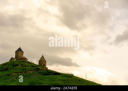 La Géorgie, Trinity Church sur la montagne contre l'arrière-plan de roches dans le village de sur Gergeti la route militaire géorgienne Banque D'Images