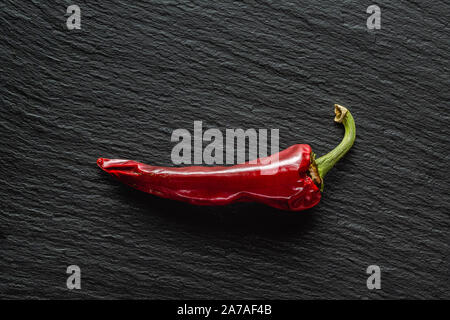 Seul le poivre rouge banane séchée sur une ardoise gris foncé with copy space Banque D'Images
