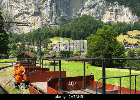 Un train passe montagne suisse une équipe de travailleurs d'entretien de la voie près de Lauterbrunnen Suisse Banque D'Images