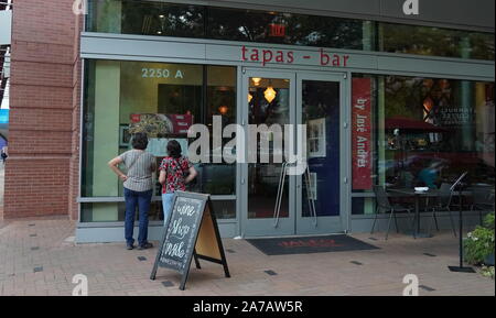 Arlington, VA / USA - 23 septembre 2019 : deux femmes regardez le menu en face d'un restaurant à tapas, à la recherche de leur prochain repas Banque D'Images