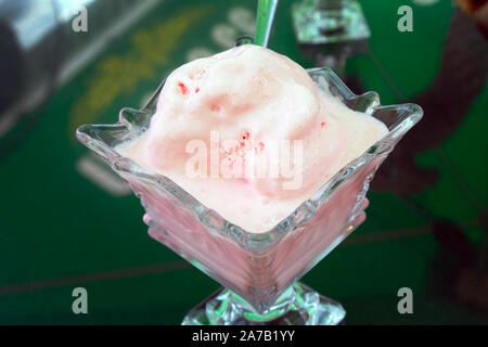 Glace à la fraise rose vue d'en haut. Sur la table est un vase en verre avec de la glace. Savoureux desserts dans un café d'été en Géorgie. Banque D'Images