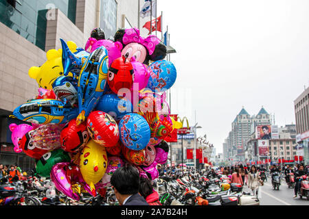 Personnages de dessins animés Disney ballon vu vendre dans les rues de Chongqing City, province de Jiangsu, Chine. Chine drapeau et le logo de McDonald's en arrière-plan. Banque D'Images