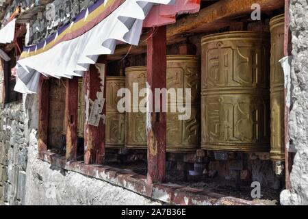 Walkway bordée roues de prière dans le monastère de Palcho dans Gyantse, Préfecture de Shigatsé, Tibet.Le mantra Om Mani Padme Hum est écrit en Sanskrit sur eux. Banque D'Images