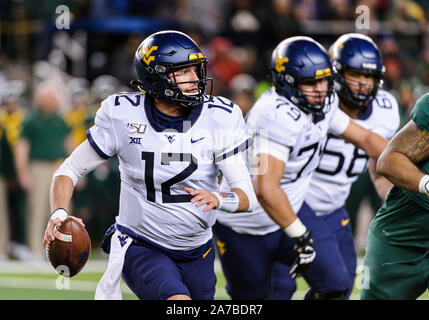 Waco, Texas, USA. 31 octobre, 2019. West Virginia Mountaineers quarterback Austin Kendall (12) sort de la poche pendant la 2ème moitié de la NCAA Football match entre West Virginia Mountaineers et le Baylor Bears à McLane Stadium à Waco, Texas. Matthew Lynch/CSM/Alamy Live News Banque D'Images