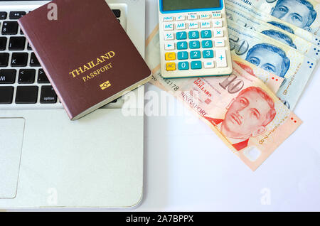 Cinquante dollars et dix dollars Singapour et de passeports et des calculatrices avec ordinateur portable sur un fond blanc Banque D'Images