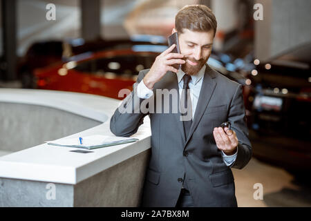 Portrait of a happy sales manager ou couple avec téléphone et se sentir heureux de vendre ou d'acheter une nouvelle voiture Banque D'Images