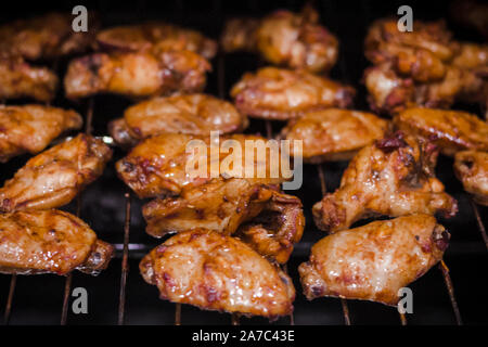 Des ailes de poulet marinées épicées et aile stick sur barbecue (BBQ) grill prêt pour le party de famille nuit. Ailes de poulet Buffalo prêt à servir c Banque D'Images