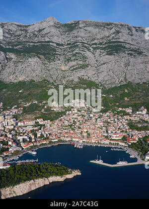 VUE AÉRIENNE.Station balnéaire au pied d'une montagne de 1400 mètres de haut.Makarska, Dalmatie, Croatie. Banque D'Images