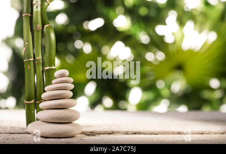 Plus de feuilles de bambou Grean pierres zen blanc pyramide sur fond de feuilles tropicales Banque D'Images