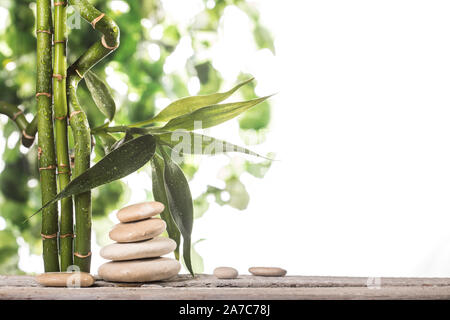 Plus de feuilles de bambou Grean pierres zen blanc pyramide sur fond blanc Banque D'Images