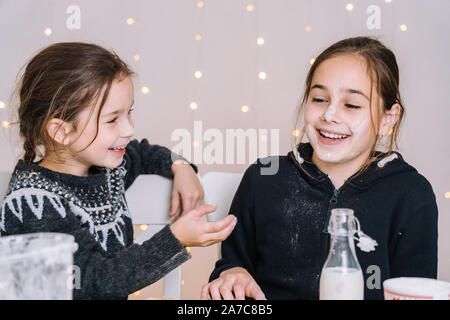 Les jeunes kids baking Christmas gingerbread cookies dans chambre cuisine sur journée d'hiver.Les enfants jouant avec la farine. Pâtisserie et en cuisine avec les enfants pour Noël à h Banque D'Images