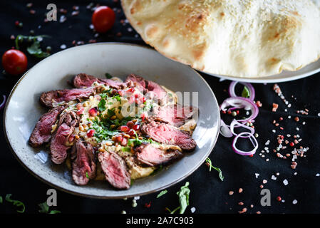 plat de houmous libanais avec bœuf rôti et graines de grenade Banque D'Images