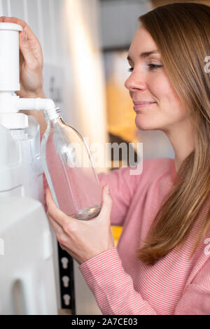 Récipient de remplissage femme avec le produit de nettoyage dans l'épicerie de plastique Banque D'Images