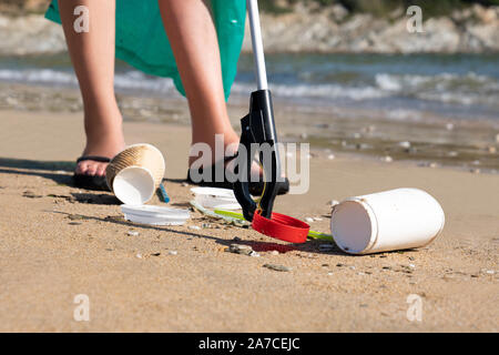 Close Up of personne recueillant les déchets en plastique à partir de la plage polluée à l'aide de déchets Banque D'Images