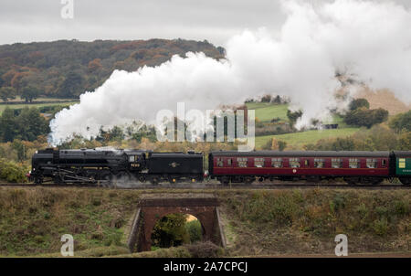 La British Railways Standard Class 9F locomotive à vapeur tire un train le long de la Hants railway, également connu sous le nom 'ligne' de cresson, près de Ropley dans le Hampshire. Banque D'Images
