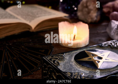 Nature morte à la bougie allumée sur la table en bois noir, carte de guichet de fortune, livre magique et fort avec pentagramme. Convient pour la magie ou ésotériques. Banque D'Images