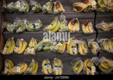 Les bananes emballées dans des emballages en plastique en vente dans un supermarché Morrisons, London, UK Banque D'Images