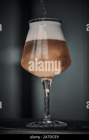 Verre de bière pendant qu'il est rempli Banque D'Images