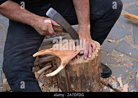 Close up d'un artisan qui sculpte le bois pour produire le masque typique de 'su boe' (le boeuf), Ottana, Italie Banque D'Images