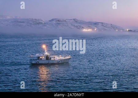 Petit bateau navigue à port au coucher du soleil. Teriberka. Mer de Barents. Kolsky District de Oblast de Mourmansk, en Russie. Banque D'Images
