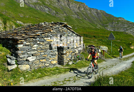 Les cyclistes passant par un grenier traditionnel sur un alpage, Alp Charmotane, Val de Bagnes, Valais, Suisse Banque D'Images