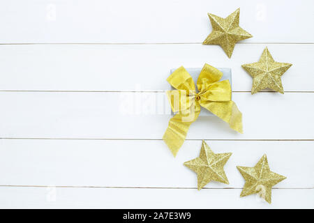 Joyeux Noël et bonnes fêtes, Noël composition. coffret-cadeau, d'étoiles d'or sur fond de bois blanc. Vue d'en haut Banque D'Images