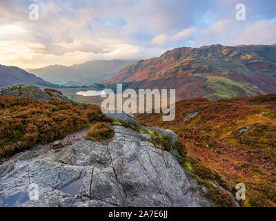 Blea Tarn est visible sous l'imposante pentes de Wrynose ont diminué au cours de l'heure d'or d'un côté autmn matin sur Pike dans le Lake District. Banque D'Images