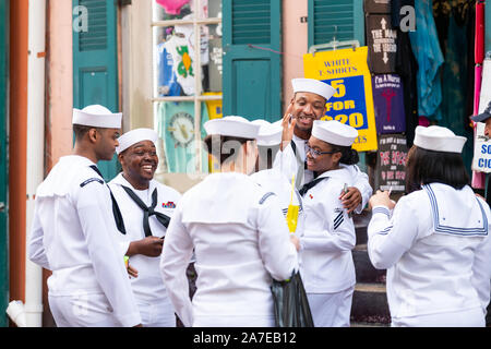 New Orleans, USA - 23 Avril 2018 : rue de la vieille ville en Louisiane ville avec des gens joyeux marins group holding drinks en conversation sur le trottoir pendant que nous Marine Banque D'Images