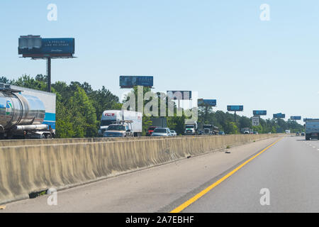 Gulfport, USA - Le 24 avril 2018 : le trafic avec de nombreux camions sur l'autoroute 10 à Biloxi, Mississippi avec rangée de panneaux d'affichage Banque D'Images