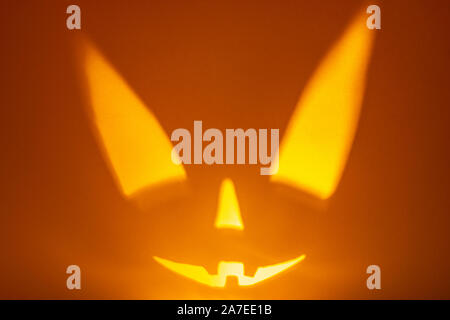 Ombre de citrouilles d'halloween visage sur fond de papier orange foncé. Ombre de l'incendie. Fond d'horreur Halloween. Copier l'espace. Banque D'Images