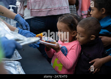 Matamoros, Mexique, 01 novembre 2019, l'enfant reçoit de la nourriture d'une organisation locale. Environ 2000 réfugiés vivent actuellement dans des tentes à côté du pont international qui relie la ville mexicaine de Matamoros avec la ville américaine de Brownsville. Credit : Lexie Harrison-Cripps/Alamy Live News Banque D'Images